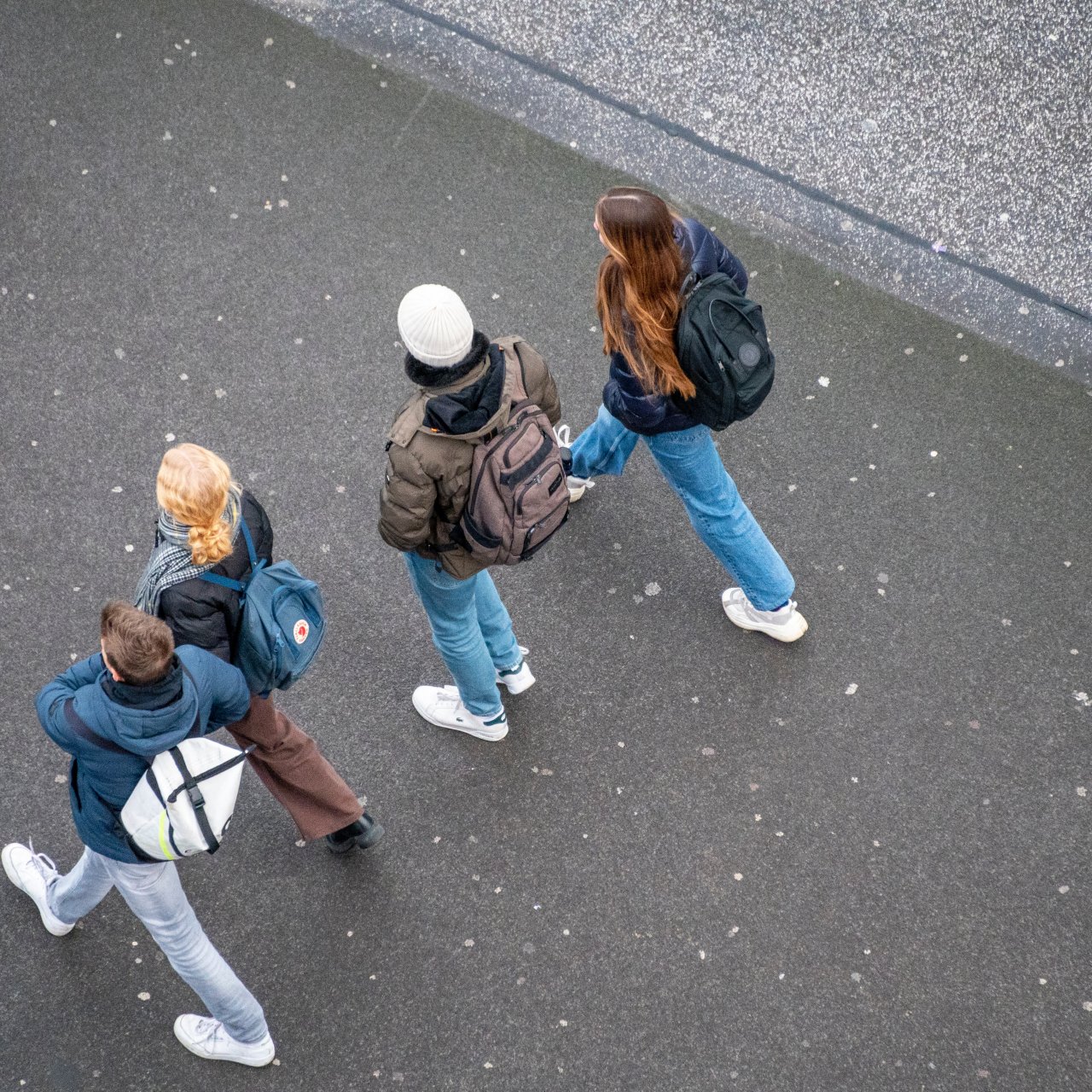 Jugendliche mit Rucksäcken laufen auf der Strasse
